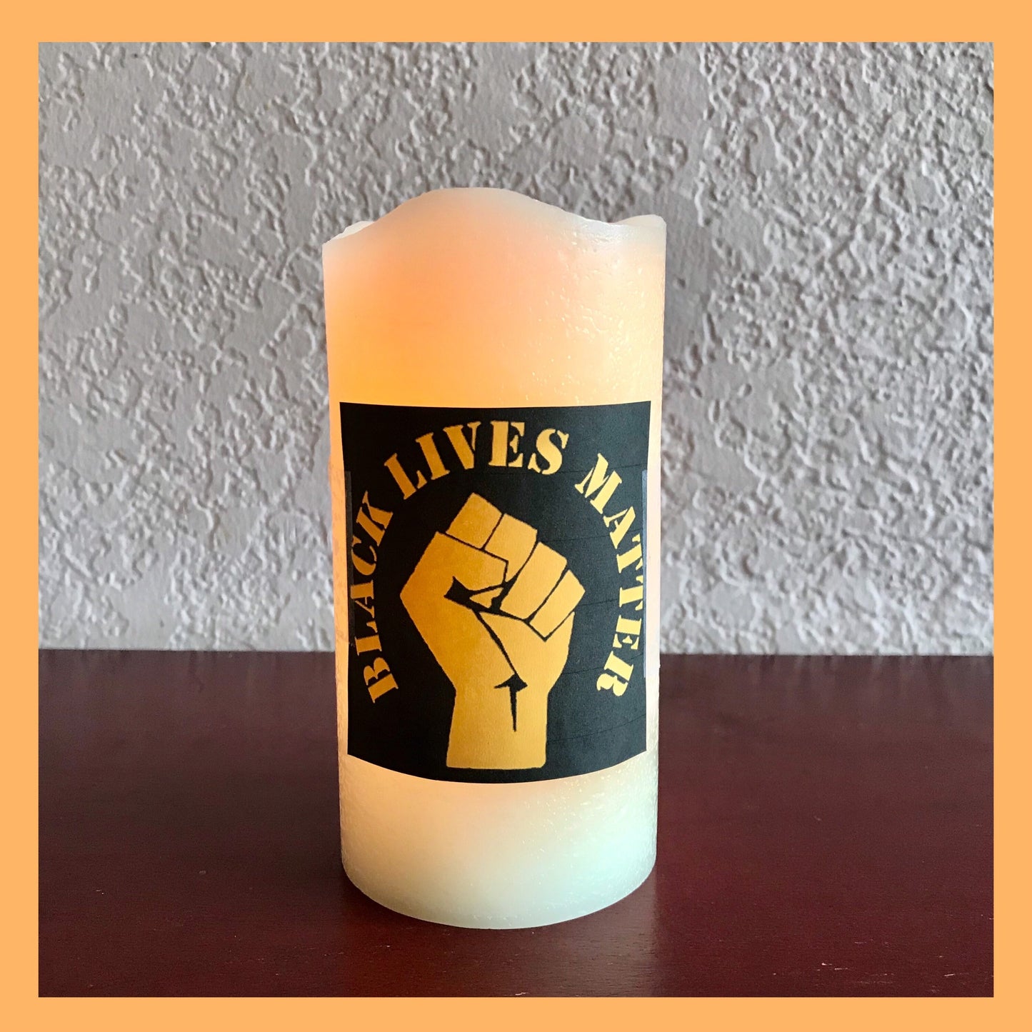 Black Lives Matter FistFlameless Real Wax - unscented Glowing Warm White LED candle. Dimensions: 3" D x 6" H (7.62 x 15.24 cm).